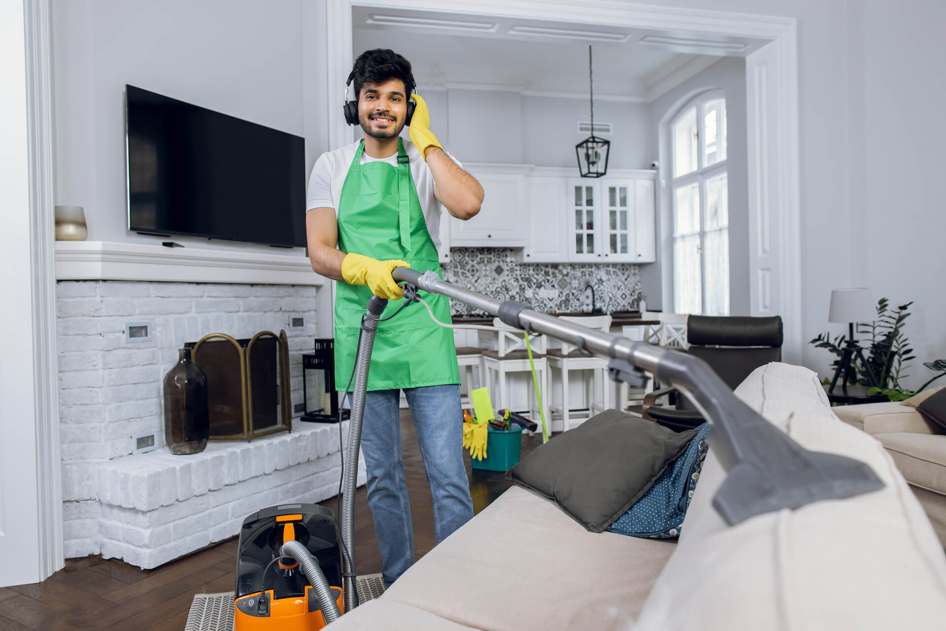 smiling-man-cleaning-sofa-and-listening-music-2021-12-09-06-25-39-utc.jpg